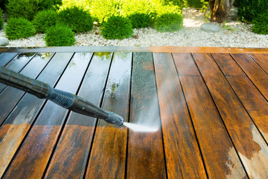 Pressure washing a wooden deck to remove dirt, mold, and algae buildup in Massachusetts home